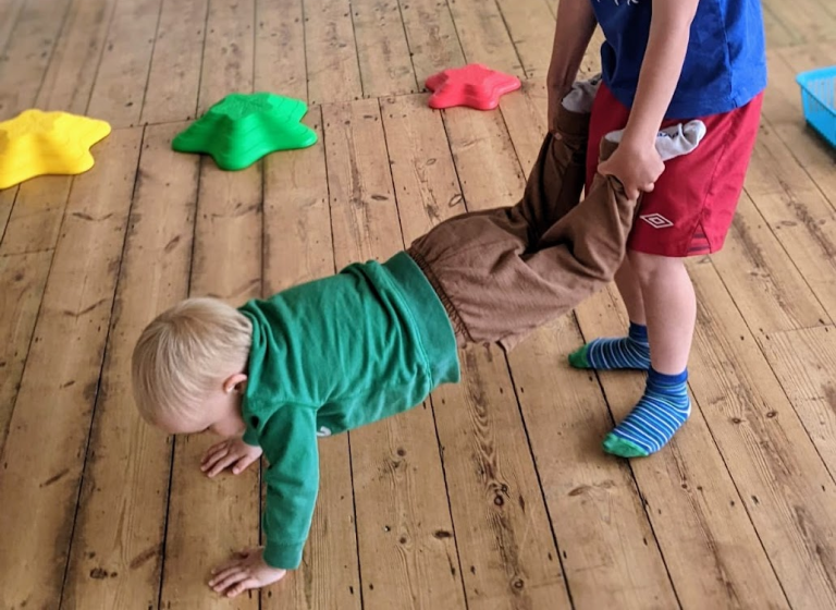 Child in superhero cape balancing at Happy Little Movers